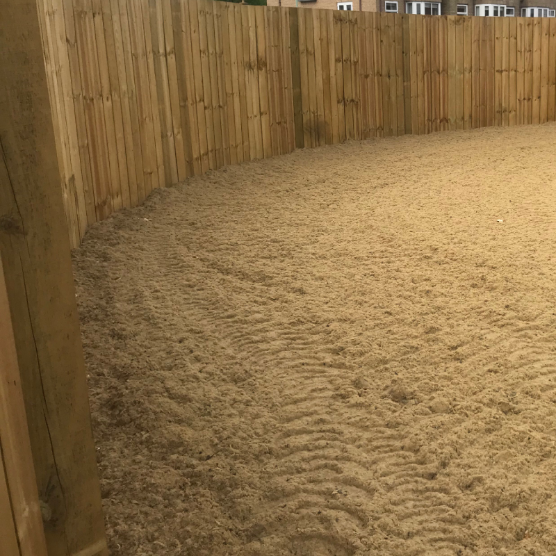 sand riding surface enclosed by closed board fencing